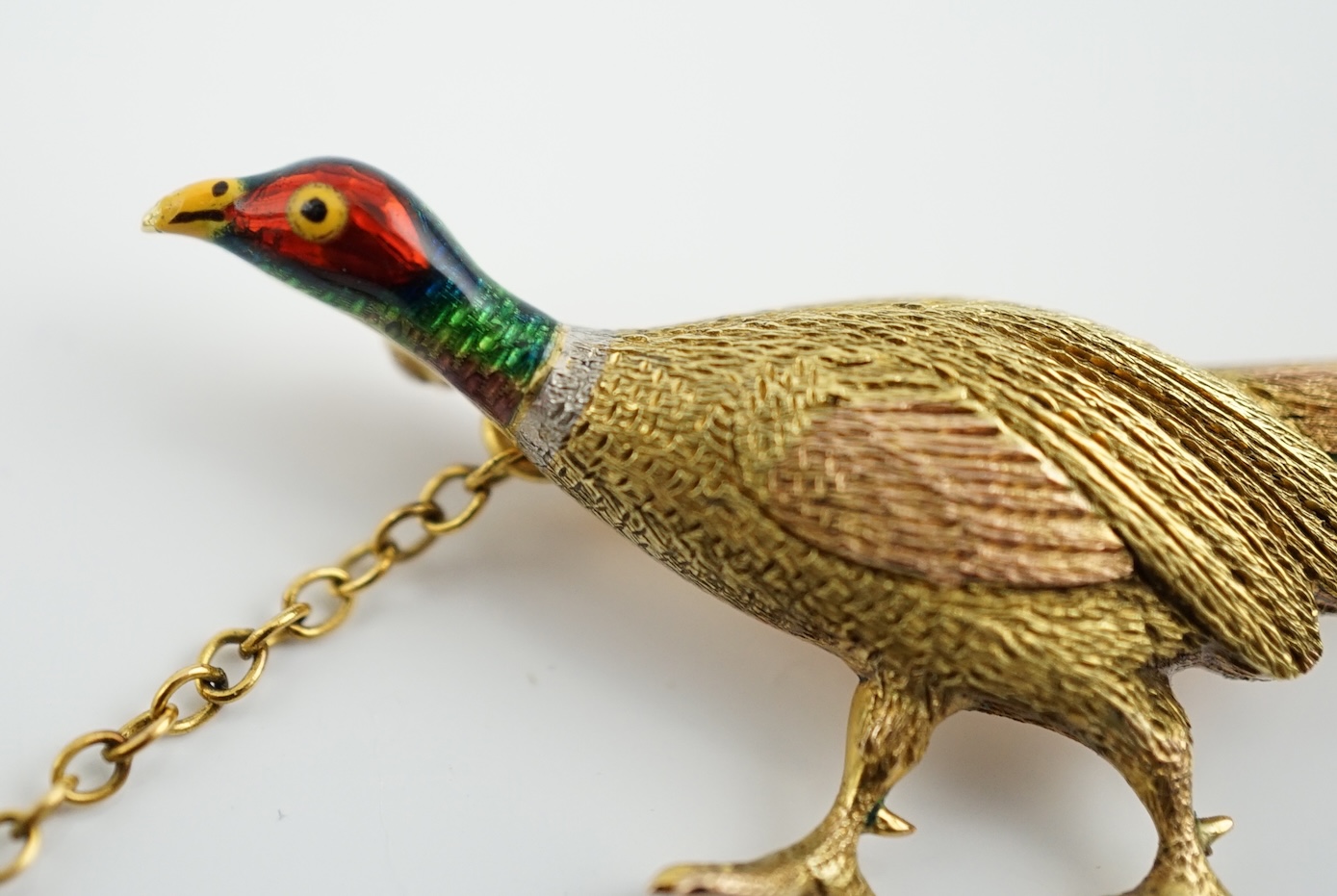 A George V three colour gold and enamelled pheasant brooch